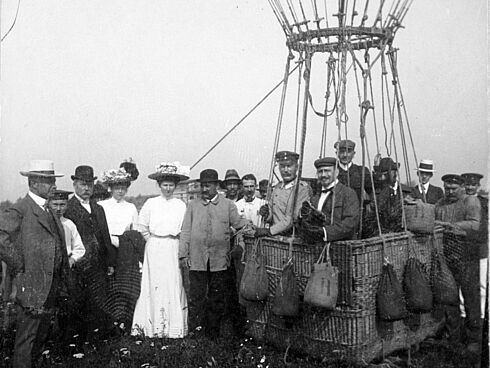 Doppelbild von Messter und einer Menschenmenge in einem Heißluftballon am Boden.
