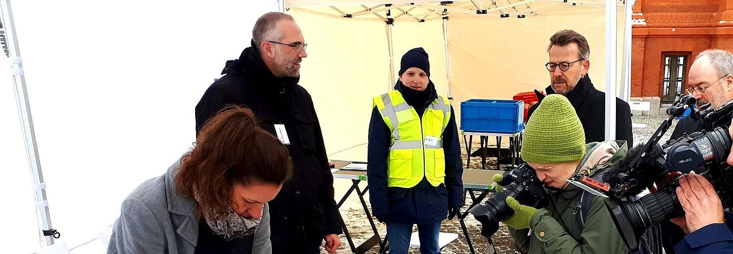 Mitarbeiterinnen und Mitarbeiter des Bundesarchivs an einem Tisch bei einer Notfallübung in Berlin-Lichterfelde