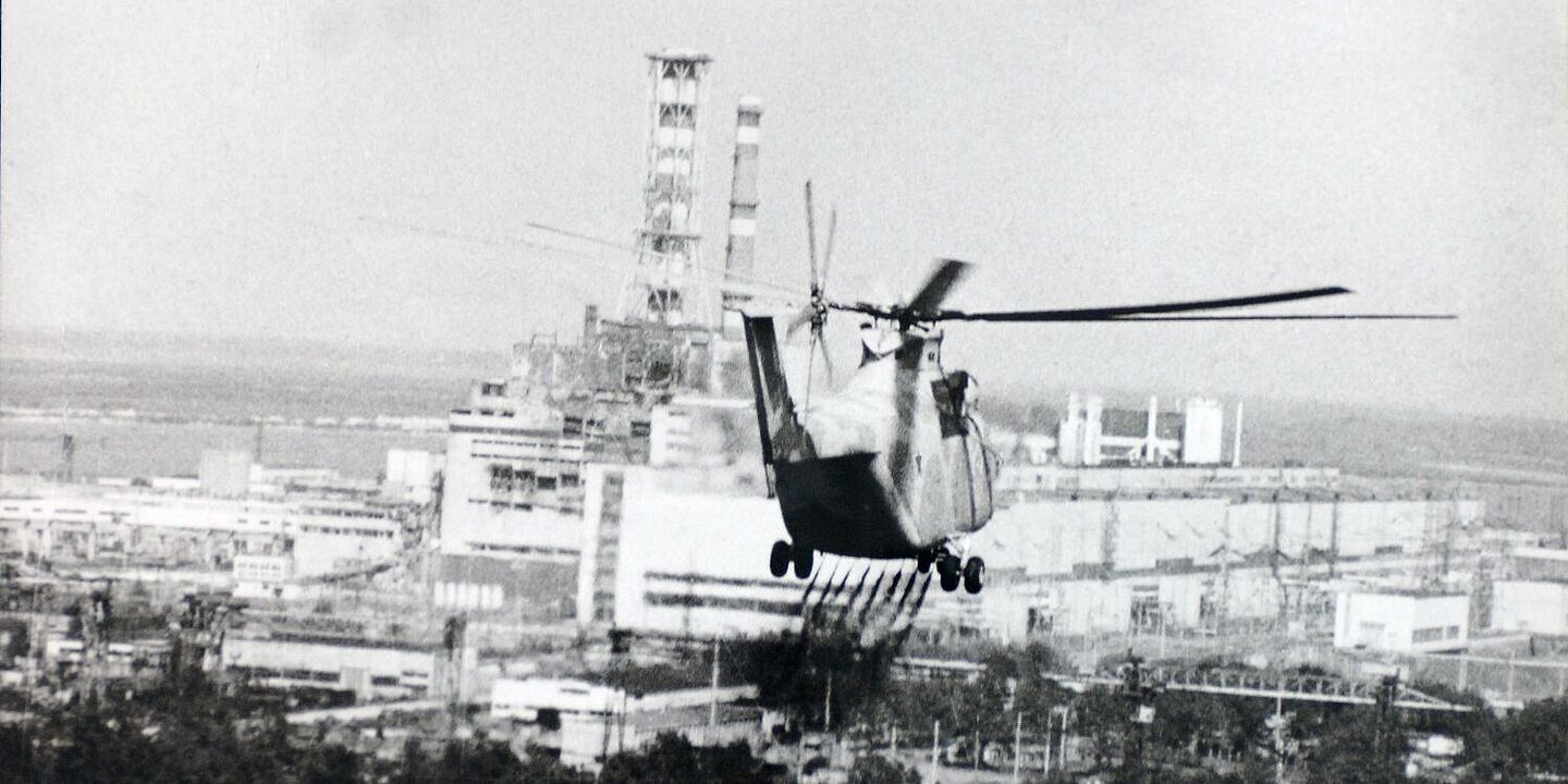 Helikopter bei Arbeiten in der Nähe des havarierten Kernkraftwerks Tschernobyl (1986) Ein Helikopter versprüht eine Flüssigkeit über einem Waldgebiet. Im Hintergrund ist das verunglückte Kernkraftwerk Tschernobyl zu sehen., Quelle:
IAEA Imagebank / USFCRFC (Lizenz: CC BY-SA 2.0)