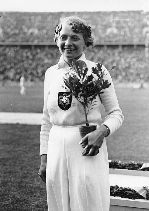 Die Speerwerferin Tilly Fleischer mit Siegerkranz und Olympia-Eiche
