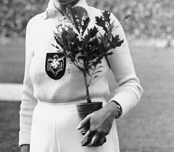 Die Speerwerferin Tilly Fleischer mit Siegerkranz und Olympia-Eiche
