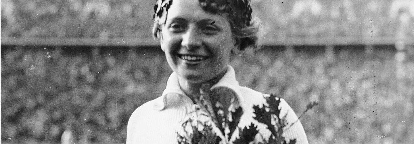 Die Speerwerferin Tilly Fleischer mit Siegerkranz und Olympia-Eiche