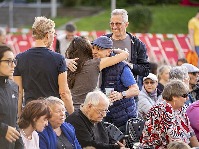 Das Foto zeigt sich umarmende Besucher zur Vorführung von "Zuckersand" beim Campus-Kino 2025
