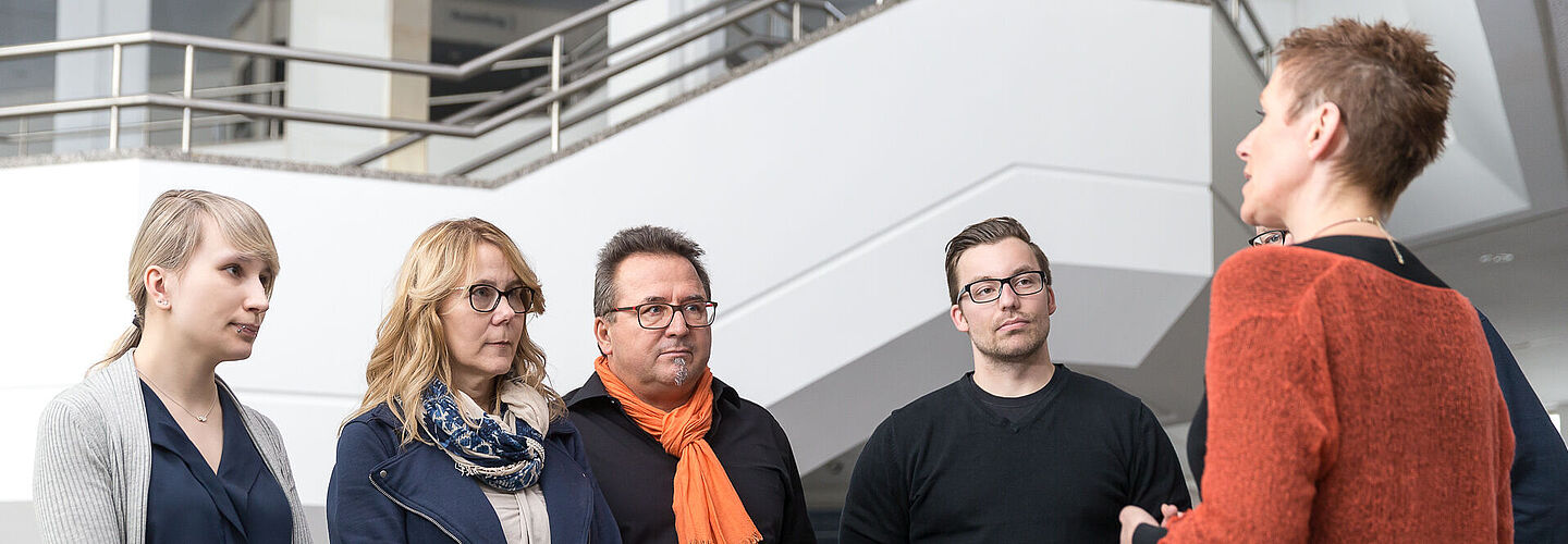 Visitors at the Bundesarchiv A group of four visitors listens to a guide at the Bundesarchiv