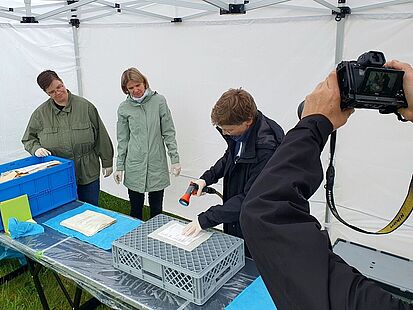 Drei Personen beim Abspülen beschädigter Akten