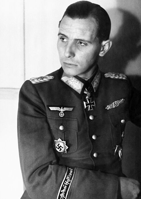 Schwarz-Weiß-Porträtaufnahme von Otto-Ernst Remer in Uniform, die mit einigen Orden und Abzeichen behangen ist; Kopf und Blick sind nach rechts gewandt