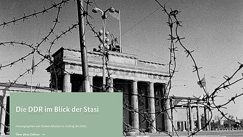 Das Bild zeigt einen Ausschnitt der Startseite der ZAIG-Datenbank "DDR im Blick der Stasi". Zu sehen ist ein Schwarz-Weiß-Bild des Brandenburger Tors, das etwas durch Stacheldraht im Vordergrund verdeckt wird. Darüber befindet sich ein mintgrün hinterlegtes Textfeld mit dem Text: " Die DDR im Blick der Stasi Herausgegeben von Daniela Münkel im Auftrag des BStU"