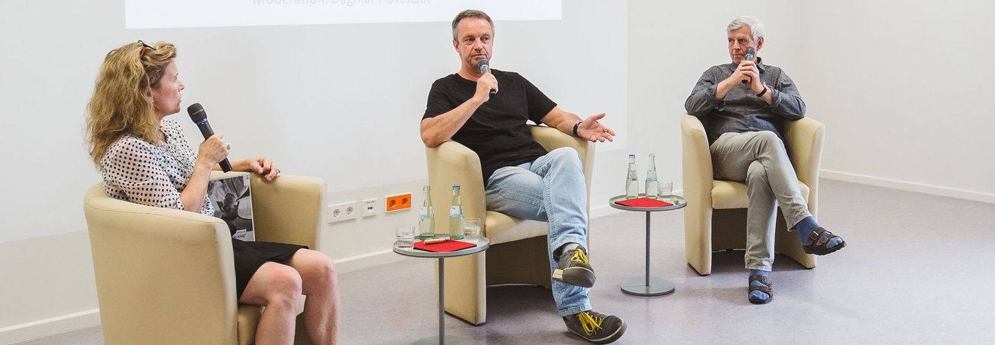 Zeitzeugen im Gespräch bei einer Veranstaltung Die Zeitzeugen Nikolaus Becker (mitte) und Gilbert Furian (rechts) im Gespräch mit Moderatorin Dagmar Hovestädt (links)