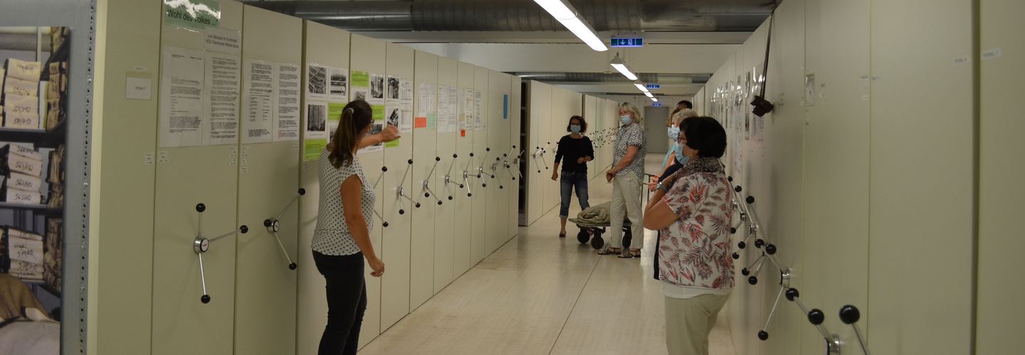 Personengruppe in einem Gang des Magazinraums