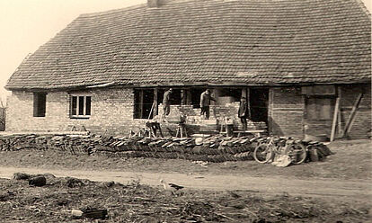Sanierungsbedürftiges Haus, bei dem Außenwände neu gemauert werden.