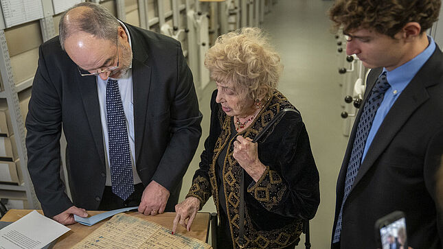 Im Aktenmagazin liest Tova Friedman in einem Buch mit 'Sonderzügen der Deutschen Reichsbahn', die von ganz Europa aus auch nach Auschwitz führten