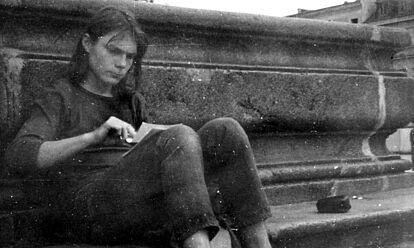 Matthias Domaschk sitzt auf einem Bordstein am Marktplatz Jena. Er blättert durch mehrere Zettel, die er sich auf den Schoß gelegt hat.