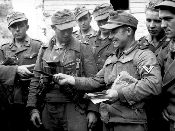 Obergefreiter verteilt Post an eine Soldatengruppe in Frankreich