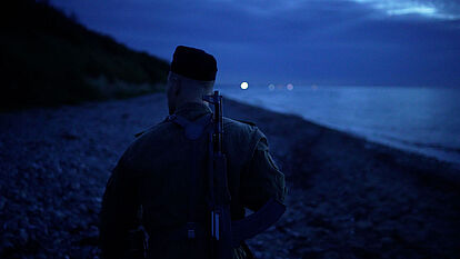 Rückansicht eines Grenzsoldaten am Strand