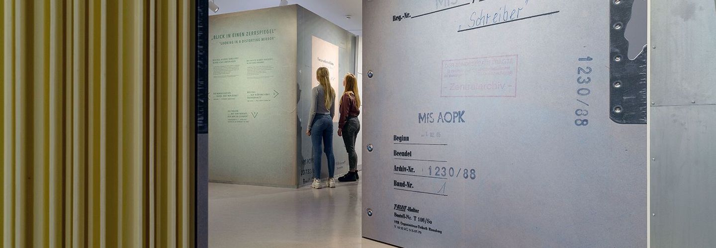 Das Bild zeigt Besucherinnen der Ausstellung „Einblick ins Geheime“, die sich die begehbare Akte anschauen