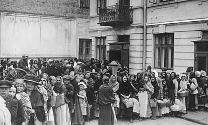 Menschenschlange von Frauen und Kindern, zum Teil mit Weidenkörben