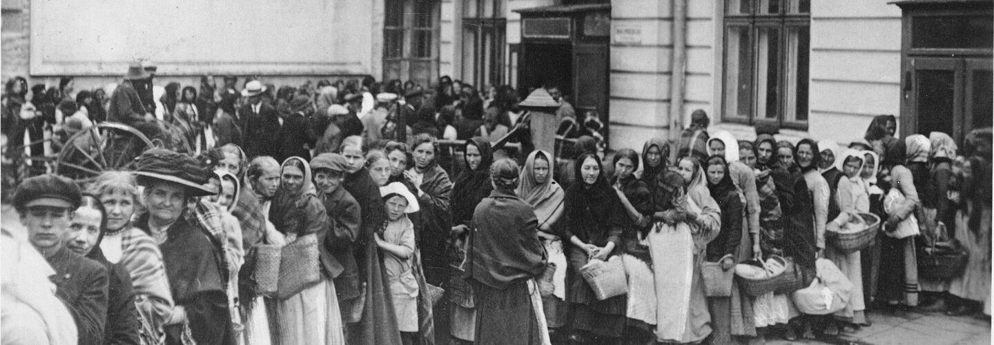 Menschenschlange von Frauen und Kindern, zum Teil mit Weidenkörben