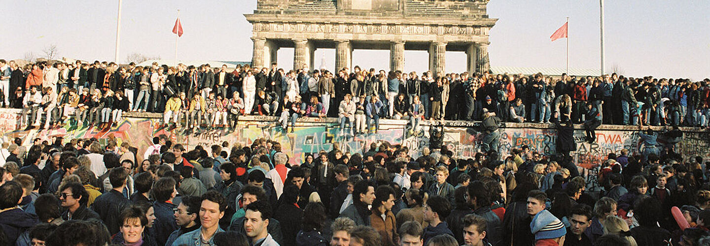 Menschen drängen sich vor der Mauer am Brandenburger Tor in Berlin am 10.11.1989