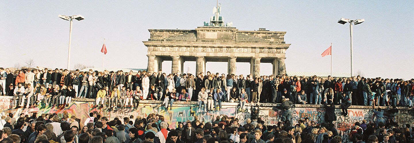 Menschen drängen sich vor der Mauer am Brandenburger Tor in Berlin am 10.11.1989