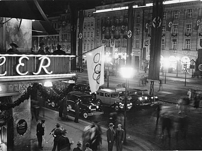 Olympischer Fahnenschmuck am Cafe Kranzler in der Straße „Unter den Linden“ während der Olympischen Sommerspiele 1936 in Berlin