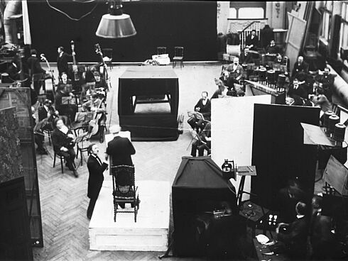 Aufnahme des Blüthner-Orchesters für einen sog. Dirigentenfilm im Messter Atelier Berlin, Blücherstrasse. Am Dirigentenpult steht Generalmusikdirektor Ernst von Schuch (1846 - 1914), links daneben der junge Dirigent und Komponist Guiseppe Becce.