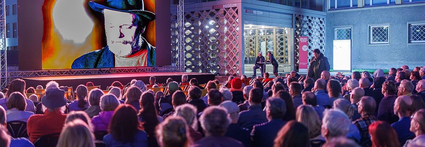 Eine Menschenmenge von hinten mit Blick auf die Leinwand beim Campus-Kino 2025