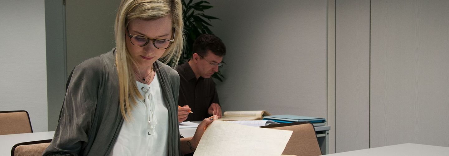 Eine Frau und ein Mann nehmen im Lesesaal des Stasi-Unterlagen-Archivs Einsicht in Stasi-Akten.