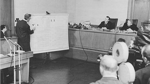 Oberstes Gericht, Fischer-Prozess, Aussage, Fischer Zentralbild Kohls-11.3.1966-Berlin: Prozeß gegen KZ-Arzt Dr. Fischer. 2. Verhandlungstag - 11.3.1966: Vor dem Obersten Gericht der DDR wurde der Angeklagte Fischer zur Sache vernommen. Er wird beschuldigt, als SS-Lagerarzt und Stellvertreter des SS-Standortarztes des Konzentrationslagers Auschwitz-Birkenau in der Zeit von 1942 bis Januar 1945 Zehntausende von Häftlingen selektiert und zur Vernichtung durch Zyklon-B-Gase bestimmt zu haben. UBz: Der Angeklagte KZ-Arzt zeigt an einer Tafel die Krematorien des Konzentrationslager Auschwitz-Birkenau. Rechts: der Präsident des Obersten Gerichts der DDR, Dr. Heinrich Toeplitz; links daneben: Oberrichter Fritz Mühlberger.
