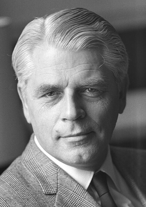 Auf dem Schwarz-Weiß-Porträtfoto ist Conrad Ahlers zu sehen. Er trägt einen Anzug mit kariertem Muster, sowie ein weißes Hemd und eine dunkle Krawatte. Das Foto wurde am 5. Juni 1970 von Jens Gathmann aufgenommen.
