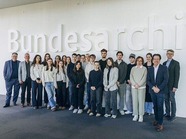 Bild einer Gruppe von Schüllerinnen und Schülern mit Vizepräsidentin und weiteren Personen vor dem "Bundesarchiv"-Schriftzug
