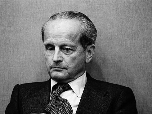 Schwarz-Weiß-Fotografie mit Günther Nollau, bekleidet mit Anzug und Krawatte und mit gesenktem Blick