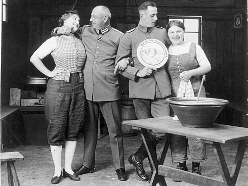 Oskar Messter Arm in Arm mit Henny Porten und Leutnant von Rosen von der Feldfliegerabt 40 zu Besuch bei den Dreharbeiten zu „Auf der Alm, da gibt