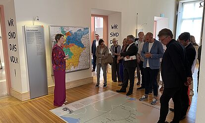 Bild mit Dr. Elisabeth Thalhofer, die eine Besuchergruppe durch die Dauerausstellung in Rastatt führt