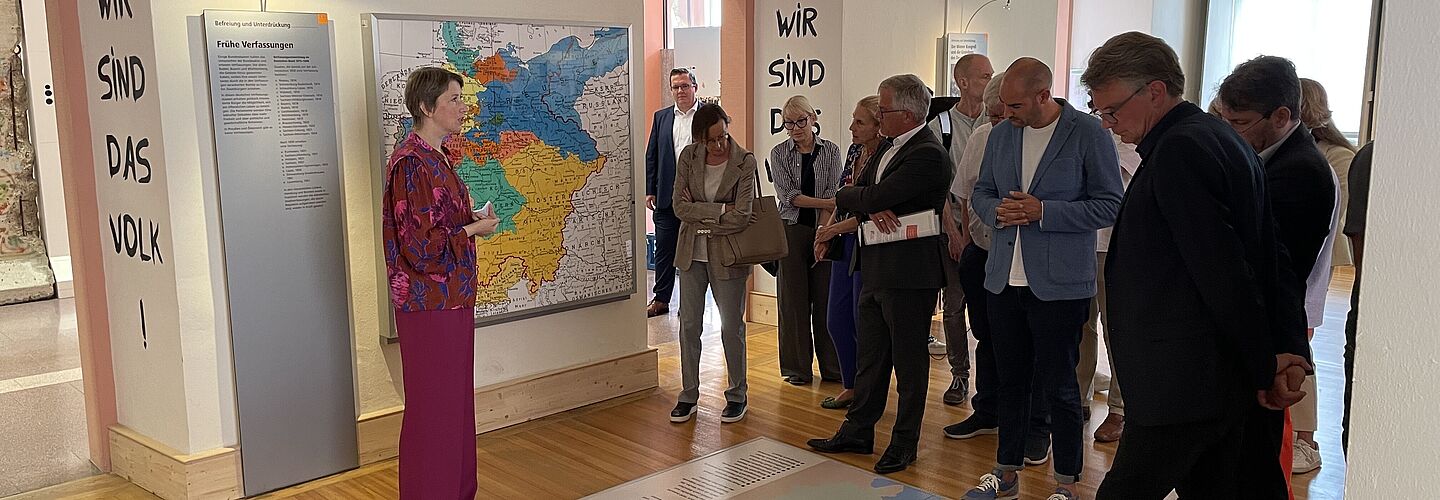 Bild mit Dr. Elisabeth Thalhofer, die eine Besuchergruppe durch die Dauerausstellung in Rastatt führt