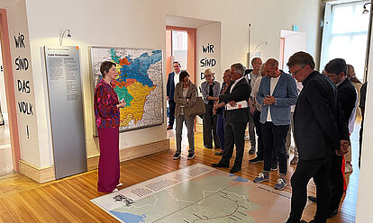 Bild mit Dr. Elisabeth Thalhofer, die eine Besuchergruppe durch die Dauerausstellung in Rastatt führt