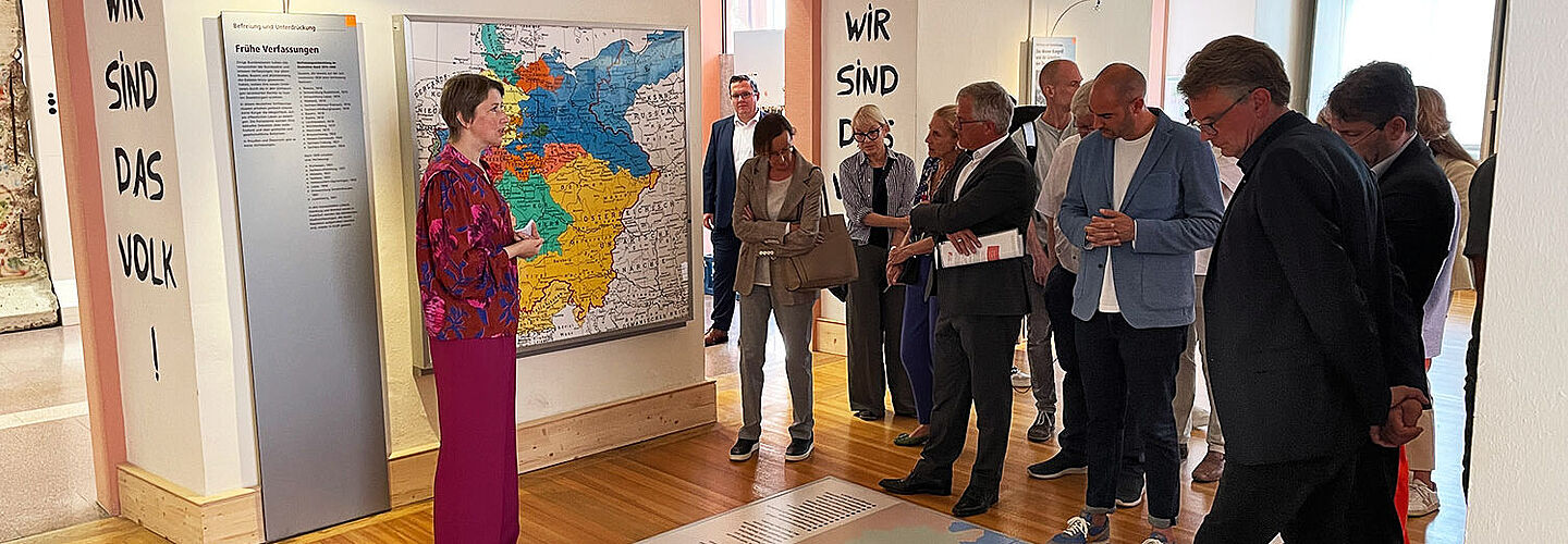 Bild mit Dr. Elisabeth Thalhofer, die eine Besuchergruppe durch die Dauerausstellung in Rastatt führt