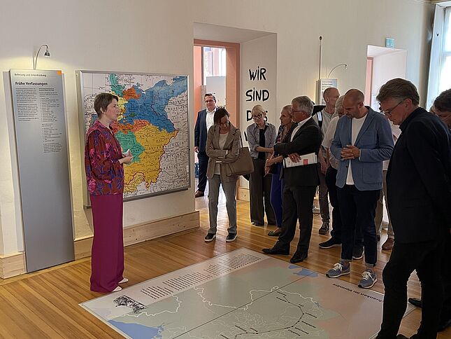 Bild mit Dr. Elisabeth Thalhofer, die eine Besuchergruppe durch die Dauerausstellung in Rastatt führt