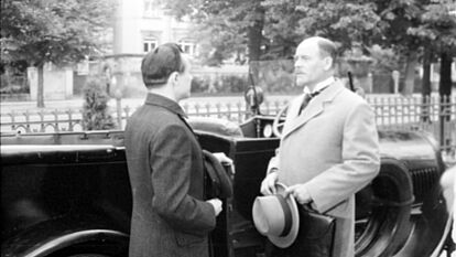 Das Bild zeigt eine Szene aus dem Film 'Mord an Rathenau' von 1961. Zwei Männer stehen sich vor einem Auto gegenüber und unterhalten sich.