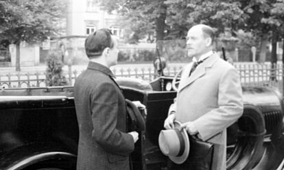 Das Bild zeigt eine Szene aus dem Film 'Mord an Rathenau' von 1961. Zwei Männer stehen sich vor einem Auto gegenüber und unterhalten sich.