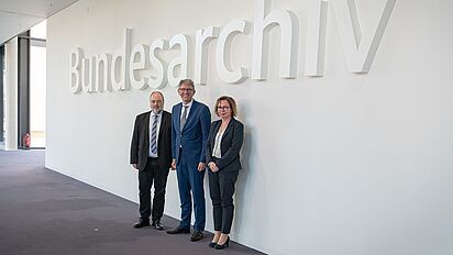 Michael Hollmann, Wolfram Weimer und Andrea Hänger stehen im Foyer des Bundesarchiv-Standorts Berlin-Lichterfelde vor dem Schriftzug „Bundesarchiv“., Quelle:
                                                Bundesarchiv / Witzel