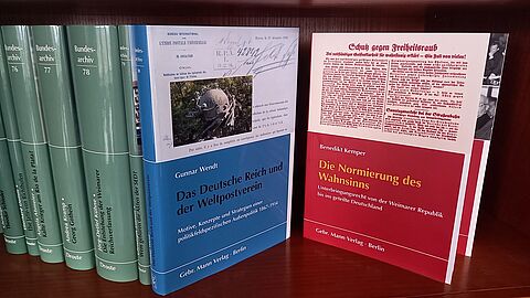 Verschiedene Publikationen des Bundesarchivs in Buchform mit grünen, blauen und roten Einbänden