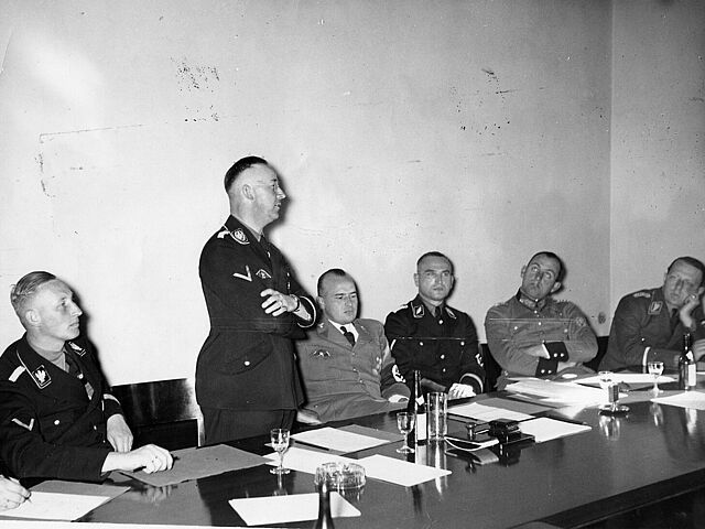 Erste Sitzung des Polizeirechtsausschusses in der Akademie für Deutsches Recht Erste Sitzung des Polizeirechtsausschusses in der Akademie für Deutsches Recht, v.l.n.r.: der Chef des Reichssicherheitshauptamtes SS-Gruppenführer Reinhard Heydrich, der Reichsführer-SS und Chef der deutschen Polizei Heinrich Himmler, Reichsminister Dr. Hans Frank (Präsident der Akademie), SS-Standartenführer Best, der Leiter des Hauptamtes Ordnungspolizei General der Polizei Kurt Daluege und der Polizeipräsident von Berlin SA-Gruppenführer Graf Wolf Helldorf, 12. Oktober 1936