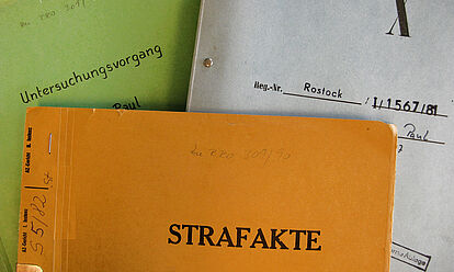 Farblich verschiedene Aktendeckel eines Untersuchungsvorganges sowie eine Strafakte