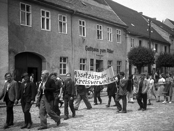 Forderung Auf einer Demonstration wird ein Plakat mitgeführt, auf dem steht: "Absetzung der Kreisverwaltung"