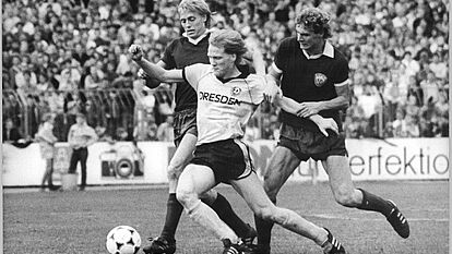 Der Dresdner Mittelfeld-Spieler Matthias Sammer mit zwei Gegnern: Rainer Ernst (l.) und Hendrik Herzog.