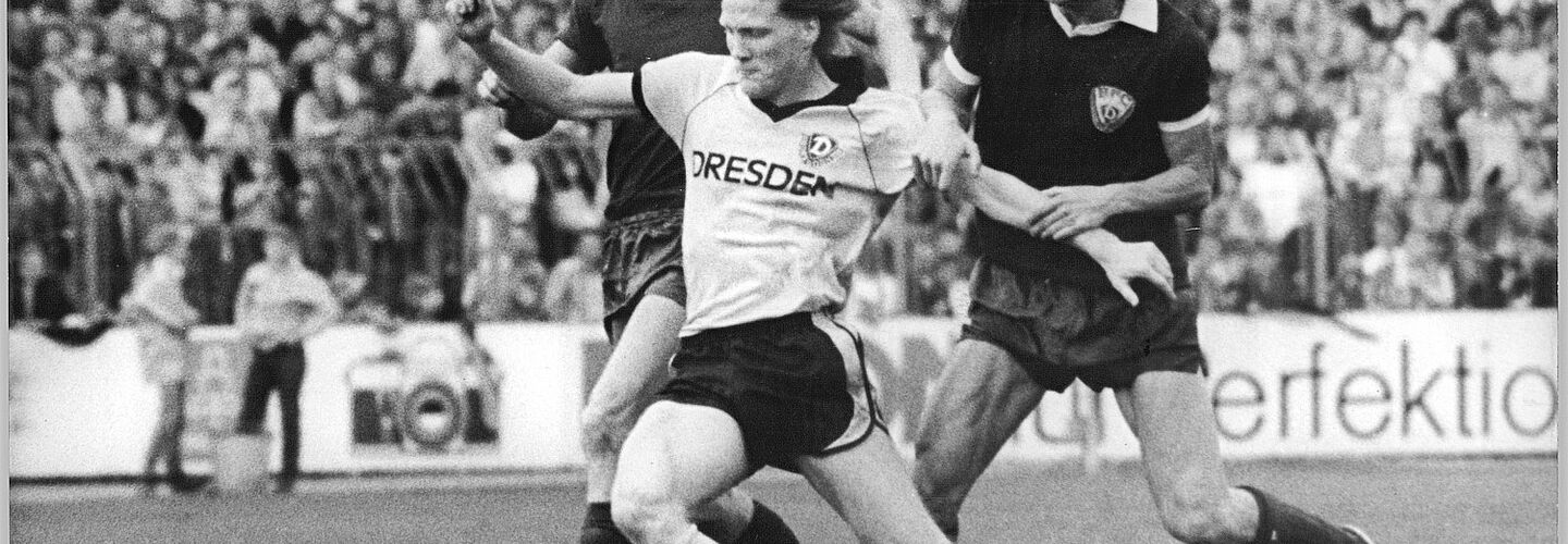 Der Dresdner Mittelfeld-Spieler Matthias Sammer mit zwei Gegnern: Rainer Ernst (l.) und Hendrik Herzog.