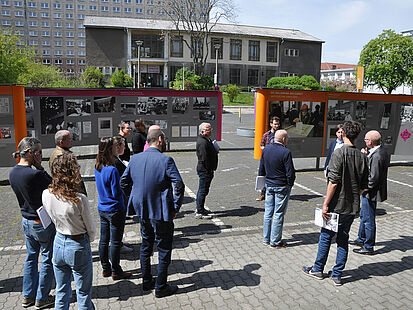 Männer und Frauen stehen im Innenhof der "Stasi-Zentrale. Campus für Demokratie" und sprechen miteinander.