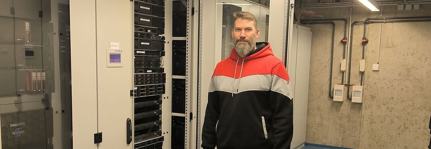 Timo Dommermuth steht im Rechenzentrum Koblenz neben einem Server.
