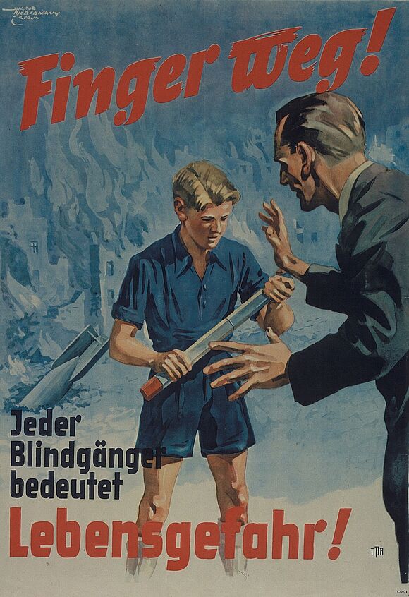 Plakat, auf dem ein Junge und ein Mann abgebildet sind. Der Junge hält eine Stabbrandbombe in den Händen, der Mann blickt ihn mit erhobenen Händen an. Im Hintergrund steckt eine Sprengbombe vor brennenden Ruinen im Boden. Auf dem Plakat steht in roten Buchstaben: „Finger weg! Jeder Blindgänger bedeutet Lebensgefahr“.