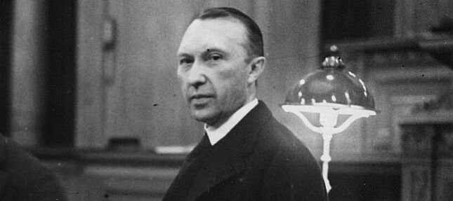 Konrad Adenauer und Adolf Freiherr von Oer stehen nebeneinander. Adenauer hält ein Blatt Papier in der Hand und schaut in die Kamera.